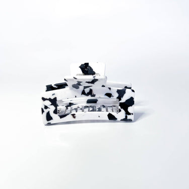 A large black and white marbled hair claw clip is presented against a white background.